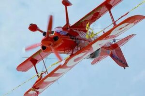 Red biplane piloted by Mike Wiskus flying upside down